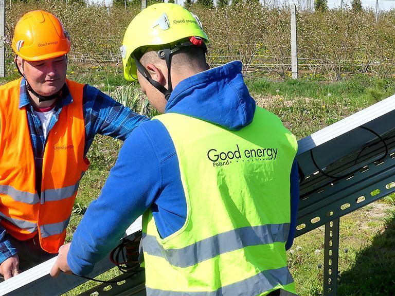 dwóch pracownikach w kamizelkach i kaskach ochronnych